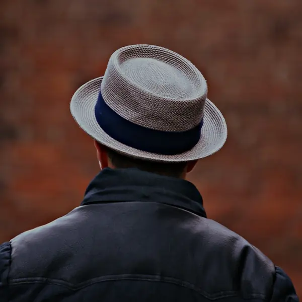 Homem usando chapéu fedora cinza com fita azul